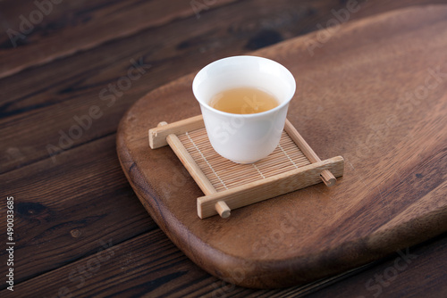 A cup of Gongfu tea is on the cutting board photo