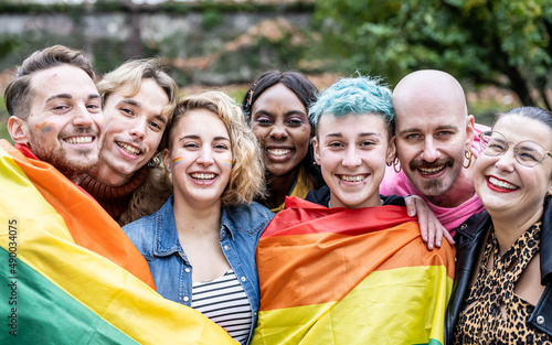 Group of young activist for lgbt rights with rainbow flag, transgenders, homosexual, queers diverse people of gay and lesbian community happy portrait