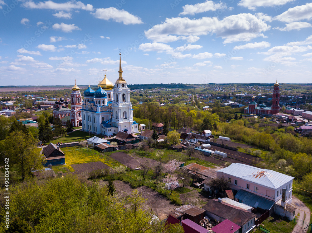 Scenic architectural ensemble of ancient Savior Transfiguration Cathedral and Trinity Church with extended bell tower on Bolkhov cityscape background, Russia