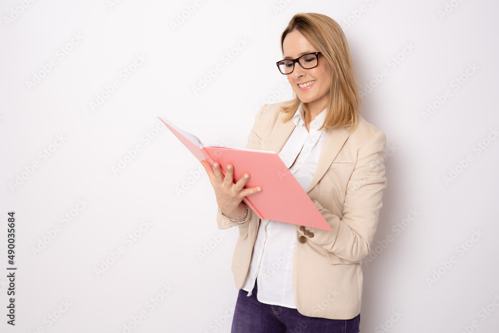 Young business woman holding a notebook standing isolated over white background. Business concept. Young business woman holding a notebook standing isolated over white background. Business concept.