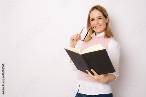 Young beautiful woman reading a book standing isolated over white background. Education concept.