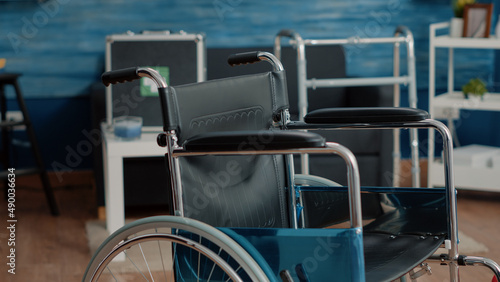 Close up of wheelchair for mobility and transportation in nursing home. Medical chair used for stationary and disabled people, supporting with handicap. Invalidity object in empty room