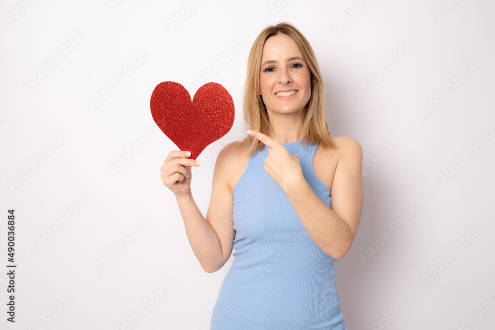 Portrait Of beautiful young woman Isolated Holding a Paper Heart Over White Background. Love concept. Portrait Of beautiful young woman Isolated Holding a Paper Heart Over White Background. Love concept.