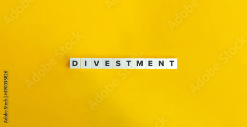 Divestment Word on Letter Tiles on Yellow Background. Minimal Aesthetics.