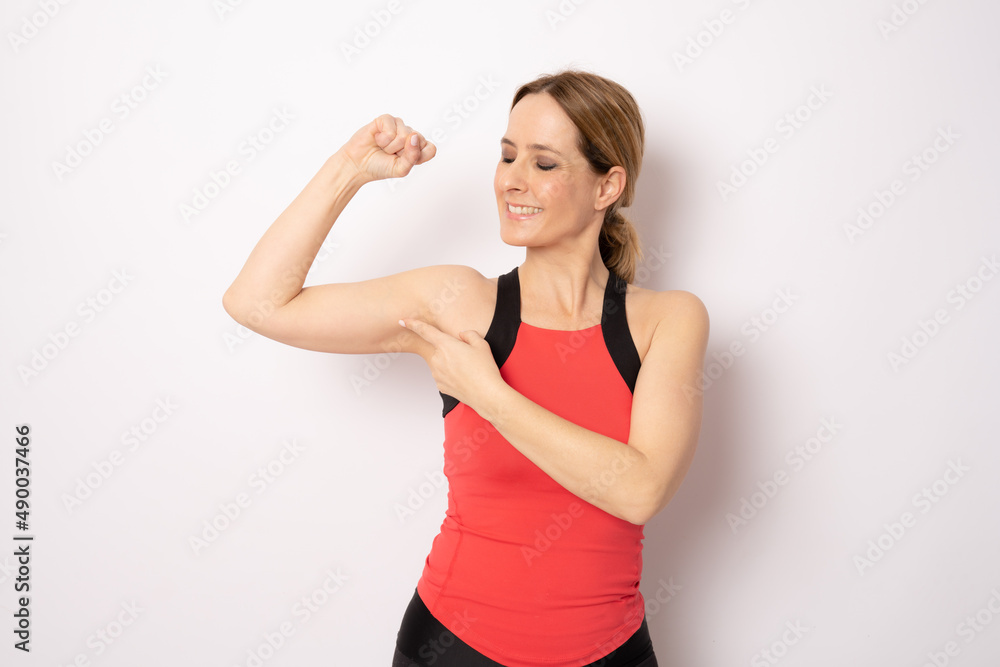 Portrait of a beautiful fitness woman showing her biceps isolated on a white background Portrait of a beautiful fitness woman showing her biceps isolated on a white background