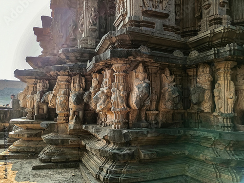 Stock photo of ruined ancient sculpture of Hindu trinity god sitting on elephant, idol carved out off gary color granite sunlight falling on idol, Picture captured at Khidrapur, Maharashtra, India. photo