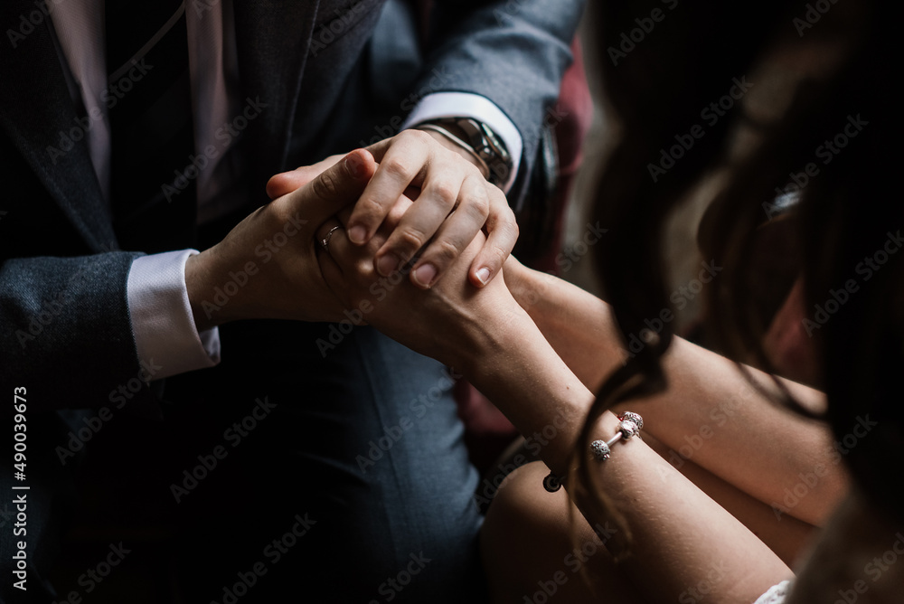 Fototapeta premium a man in a suit gently and carefully holds female hands in his hands close-up