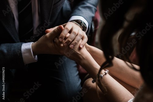 a man in a suit gently and carefully holds female hands in his hands close-up
