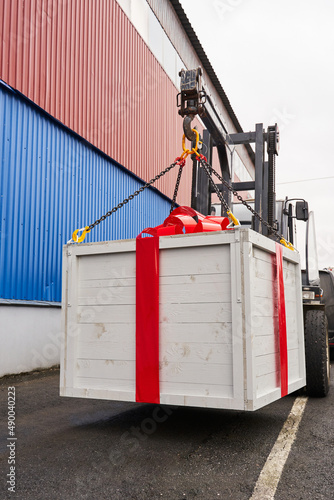 a huge white box with a gift and a huge red bow on a small lift