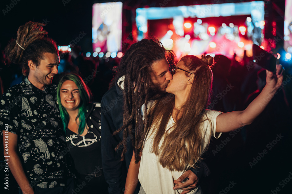 Friends at summer music festival taking selfie with a smartphone Friends at summer music festival taking selfie with a smartphone