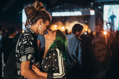 Young happy couple kissing at music festival