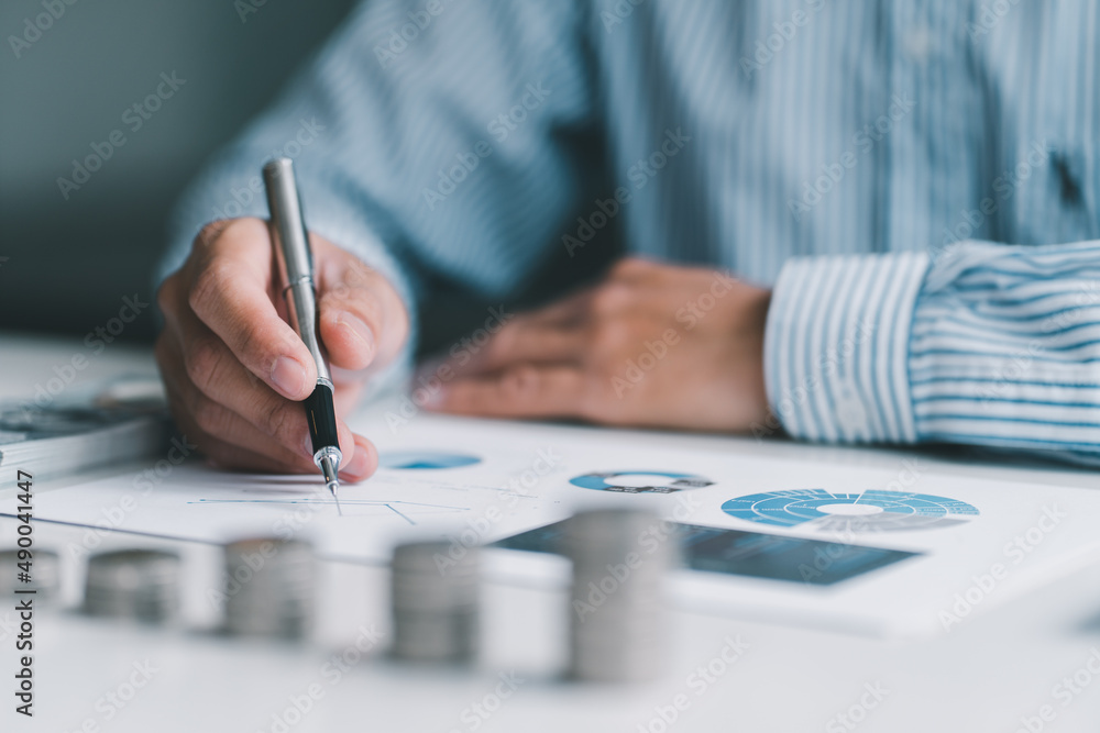 Business accountant or banker, businessman calculate and analysis with stock financial indices with stacking coin and financial costs wisely and carefully, investment and saving concept. Business accountant or banker, businessman calculate and analysis with stock financial indices with stacking coin and financial costs wisely and carefully, investment and saving concept.