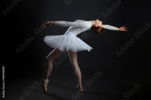 elegant ballerina made a deflection. photo shoots in the studio on a dark background