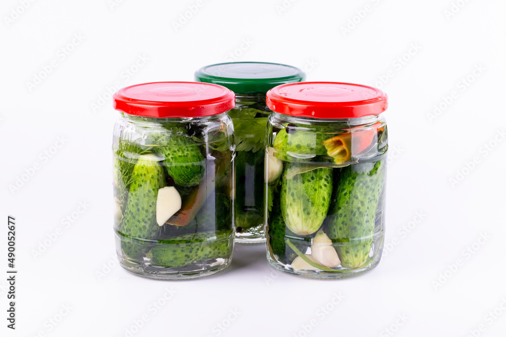Pickled cucumbers in glass jar on white background. Pickled cucumbers in glass jar on white background.