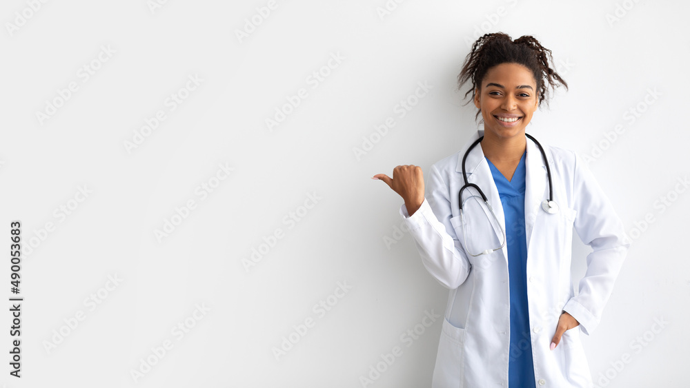 Portrait of black doctor smiling pointing at copy space Portrait of black doctor smiling pointing at copy space