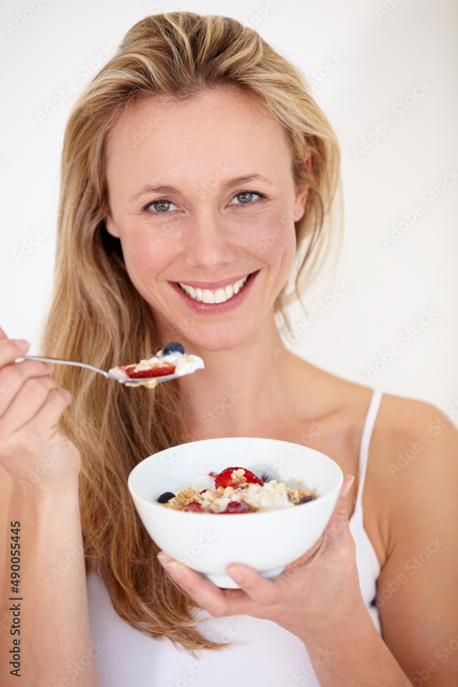 Keeping in shape. A beautiful woman enjoying a bowl of fruit and yogurt. Keeping in shape. A beautiful woman enjoying a bowl of fruit and yogurt.