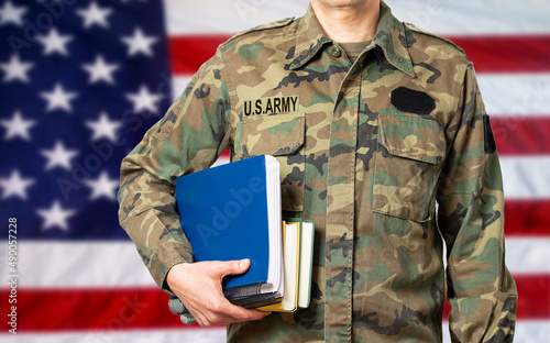Bild auf Leinwand Soldier with books in hand and ready to go back to school as a student against a