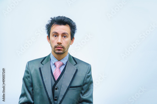 Shocked businessman with tousled hair looks into the camera.
