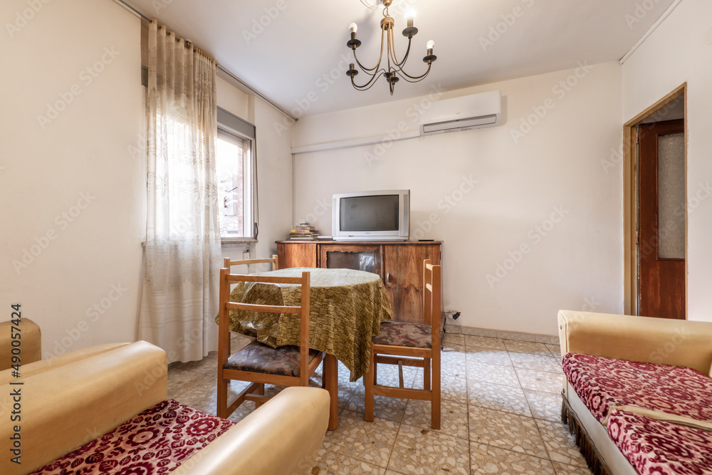 Fototapeta premium Vintage room with a stretcher table in the center and sofas with cushions upholstered with horrible fabric