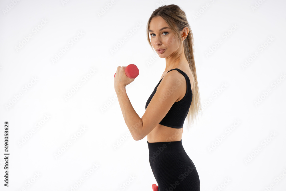 training with dumbbells of a beautiful young female on a white background training with dumbbells of a beautiful young female on a white background
