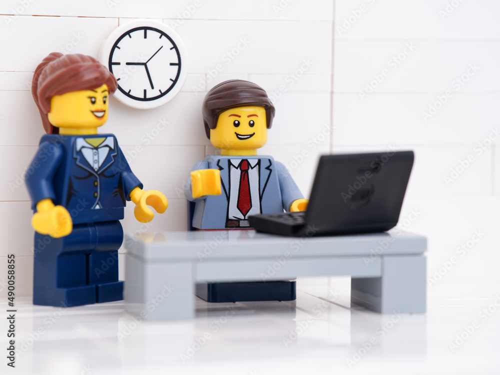 Fototapeta premium Tambov, Russian Federation - February 25, 2022 A Lego businessman and a Lego businesswoman minifigures working on a laptop in their office.