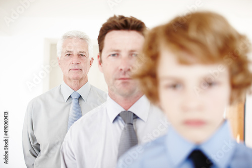 Standing in the middle of three generations. Cropped portrait of a handsome man standing with his father and his son.