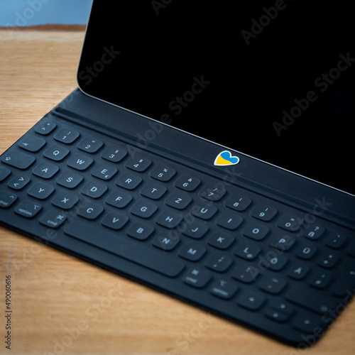 Tablet laptop keyboard with Ukraine sticker. Lots of space for text. low, selective sharpness