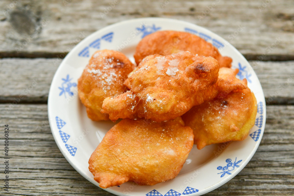 Traditional home made deep fried patties covered with sugar оn rustic backgroud.Mekitsa or Mekica, on wooden rustic background. Made of kneaded dough that is deep fried .Carnival tortelli stuff Traditional home made deep fried patties covered with sugar оn rustic backgroud.Mekitsa or Mekica, on wooden rustic background. Made of kneaded dough that is deep fried .Carnival tortelli stuff