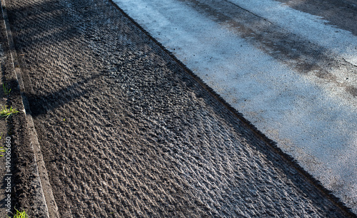 an asphalt street under renovation with milled tarmac