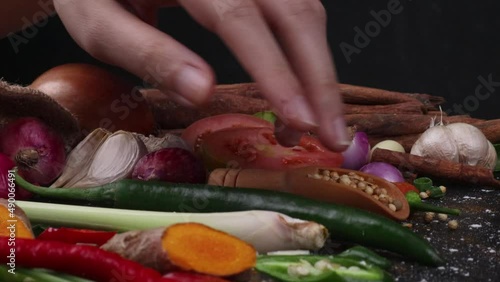 close up a hand carefuly picking up one green chilli paper on the table photo