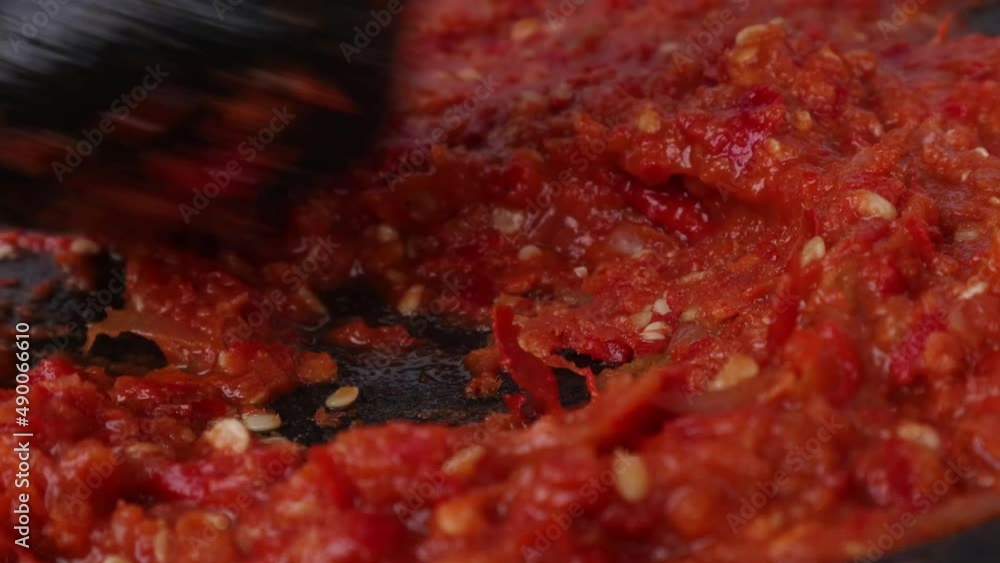 Close up mashing Indonesian tomato sambal in a stone masher stock video Close up mashing Indonesian tomato sambal in a stone masher stock video