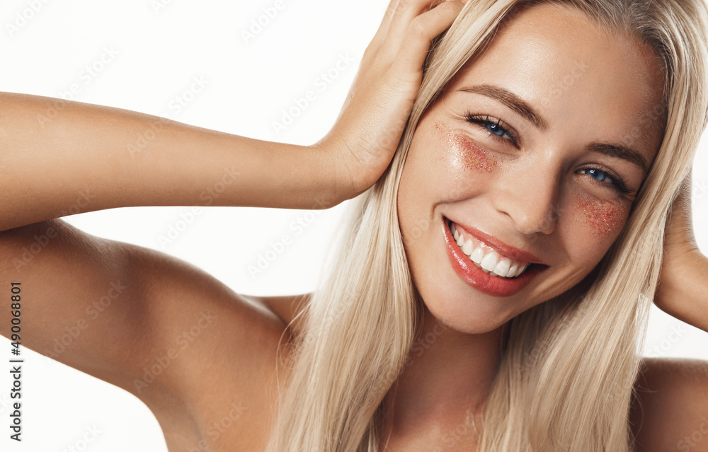 Indoor shot of calm relaxed woman has fresh healthy skin, wears collagen patches under eyes, gets facial treatment at home, apply partch from puffiness and dark circles, white background