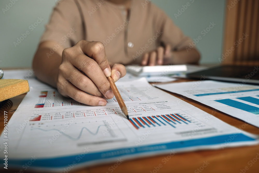 Business woman using calculator for do math finance on wooden desk in office and business working background, tax, accounting, statistics and analytic research concept Business woman using calculator for do math finance on wooden desk in office and business working background, tax, accounting, statistics and analytic research concept