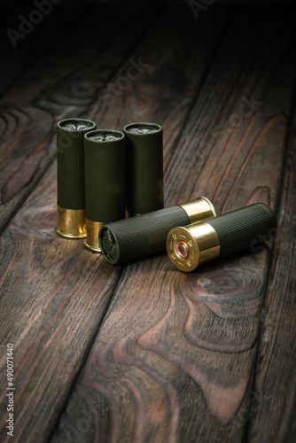 Shotgun cartridges on a brown wooden table. Ammunition for 12 gauge smoothbore weapons.