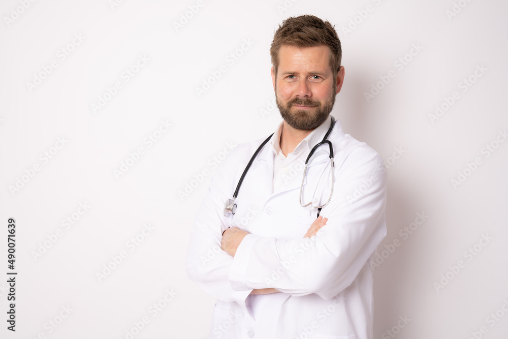 Young smiling male doctor posing with arms folded isolated on white background with copy space on the left side Young smiling male doctor posing with arms folded isolated on white background with copy space on the left side
