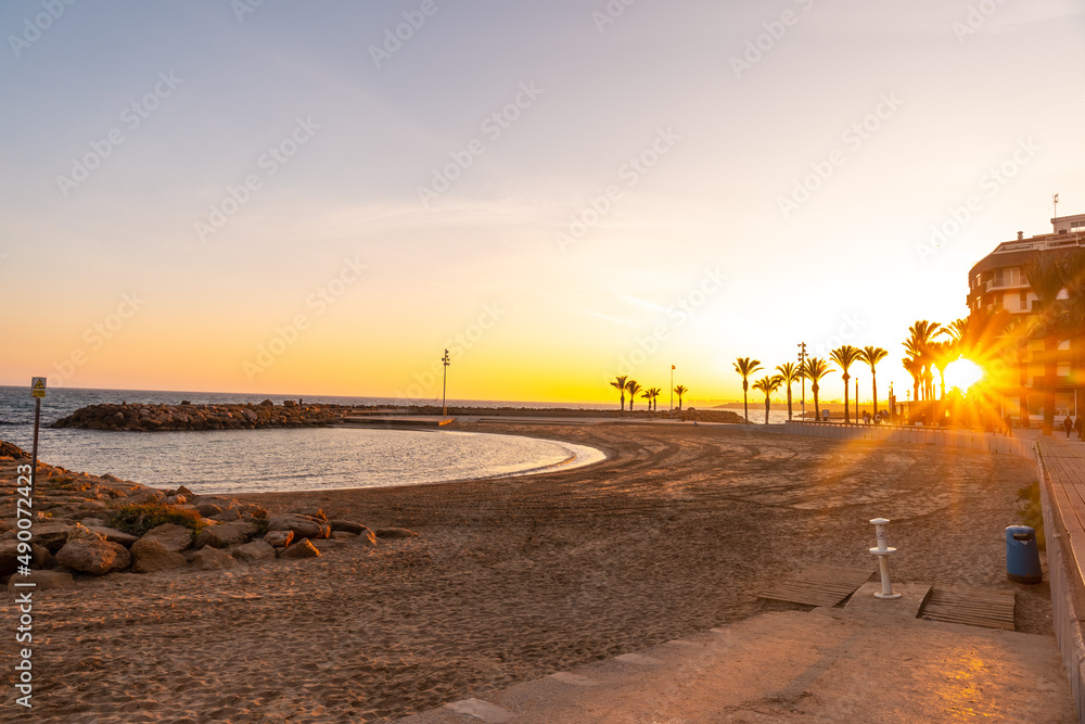Obraz premium Orange sunset at Playa del Cura in the coastal town of Torrevieja, Alicante, Valencian Community. Spain, Mediterranean Sea on the Costa Blanca