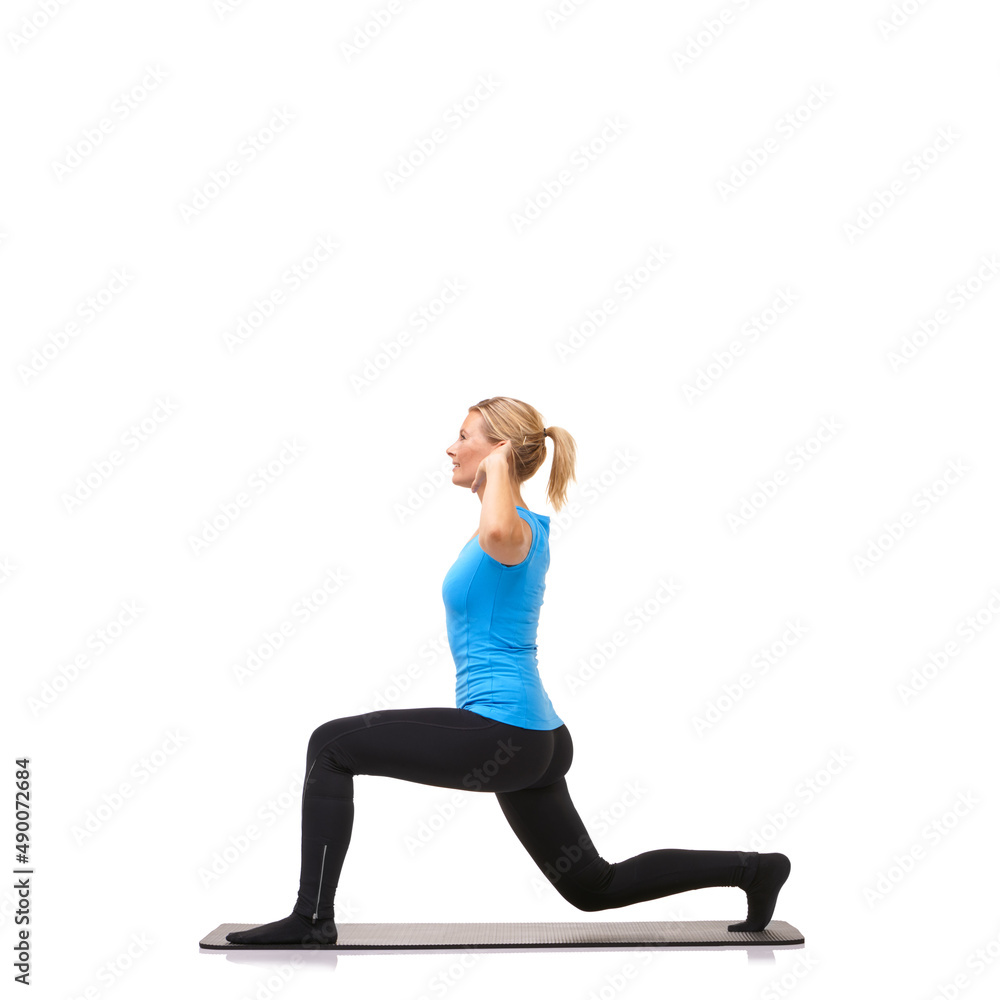 Lunging for fitness. A young woman performing lunges on her exercise mat while isolated on white.