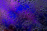 Bubbles in oil in water on blue, turquoise and purple colour abstract background