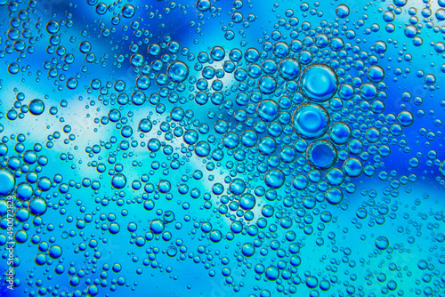 Bubbles in oil in water on blue and white colour abstract background.