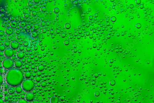 Bubbles in oil in water on green colour abstract background