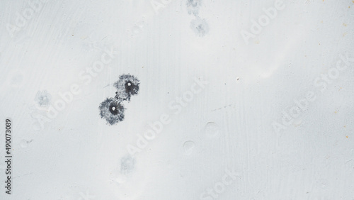 Bullet marks on the steel formed spots and holes deepened.