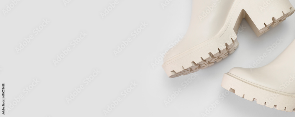 Fashionable beige leather women's boots with rough sole on light gray background top view. Trendy spring autumn shoes. Creative minimalistic shoes background. Layout with footwear Mock up Fashionable beige leather women's boots with rough sole on light gray background top view. Trendy spring autumn shoes. Creative minimalistic shoes background. Layout with footwear Mock up