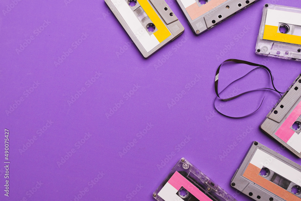 Fototapeta premium Collection of cassette tapes on purple background. Copy space fot text