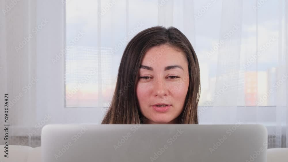 female blogger laughing while chatting with friends on social media on laptop using wireless internet in coworking space. Positive young woman shopping online on the website female blogger laughing while chatting with friends on social media on laptop using wireless internet in coworking space. Positive young woman shopping online on the website