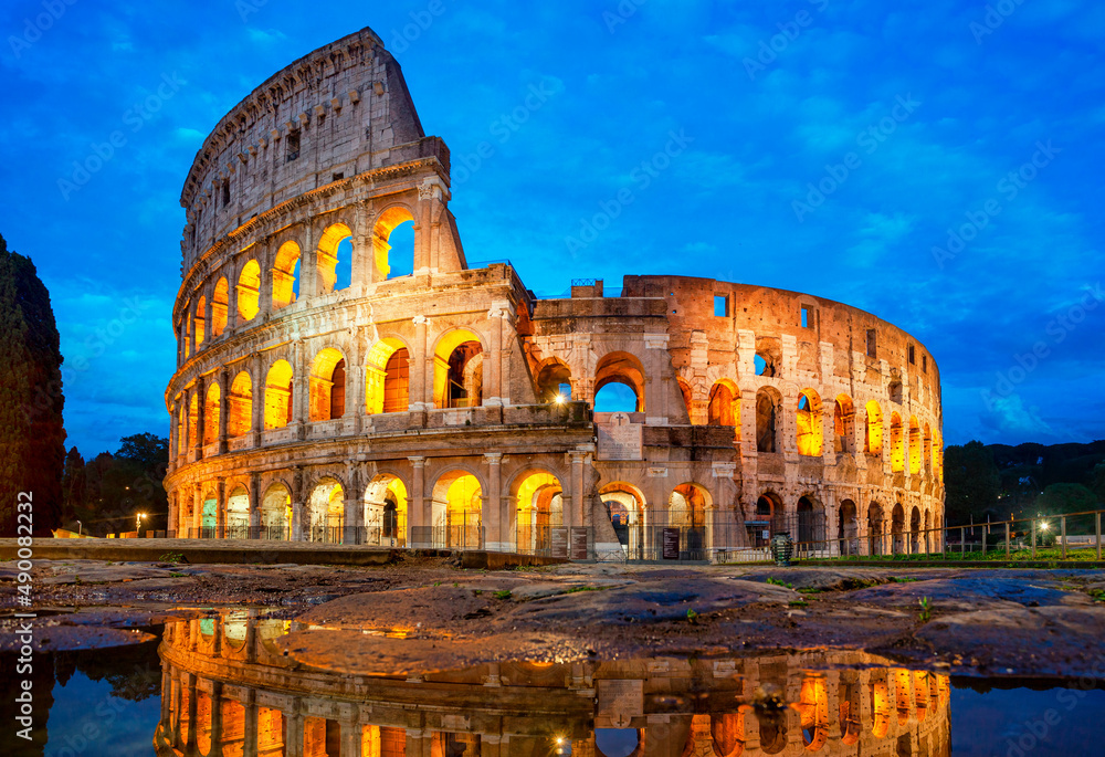 Colosseum morning in Rome, Italy. Colosseum is one of the main attractions of Rome. Coliseum is reflected in puddle. Rome architecture and landmark.