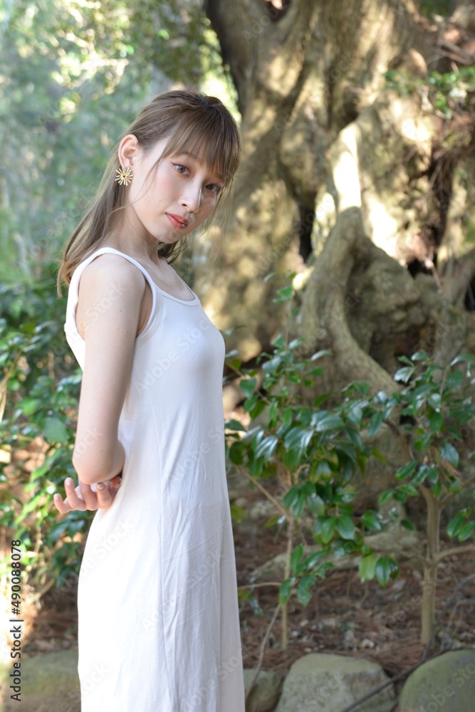 緑の森林と白いワンピースを着た若いスリムな女性 緑の森林と白いワンピースを着た若いスリムな女性