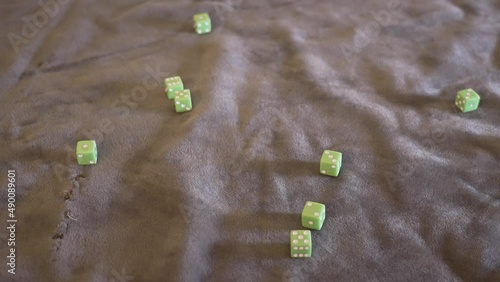 Lime green dice being dropped from above the frame in slow motion. photo