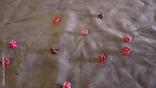A hand dropping pink and red dice of various hues into frame in slow motion. photo