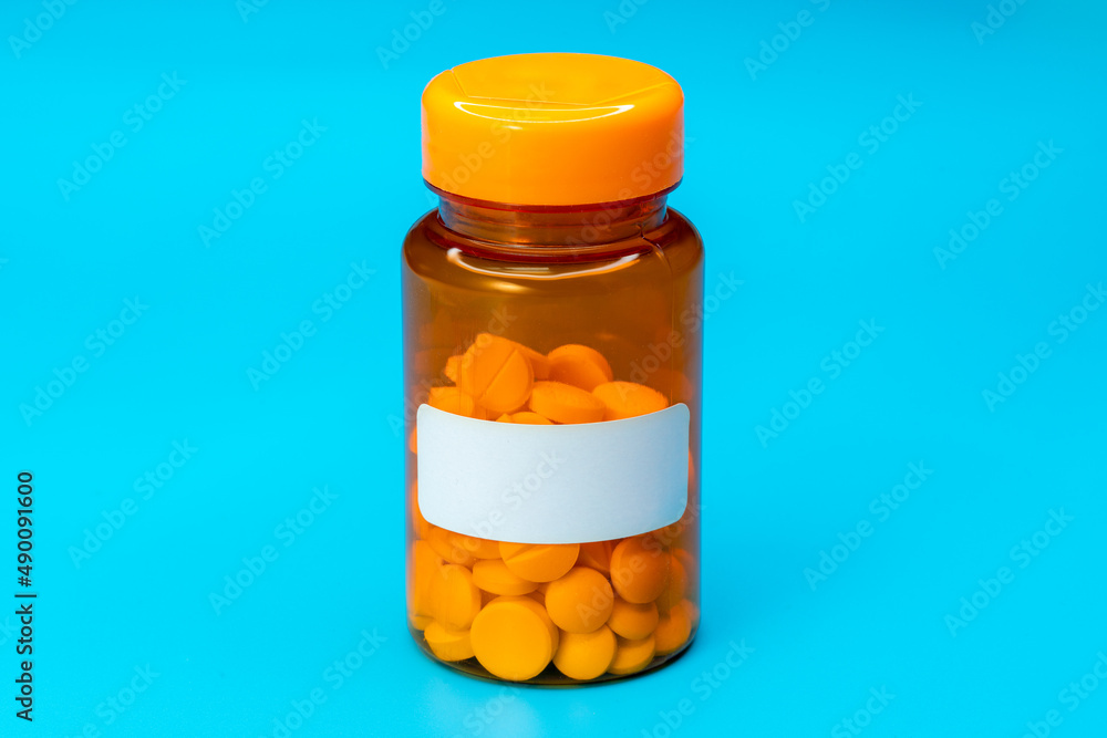 Medical vial with pills and empty label without text. Medical pills in orange Plastic Prescription. most popular medicine Medical vial with pills and empty label without text. Medical pills in orange Plastic Prescription. most popular medicine