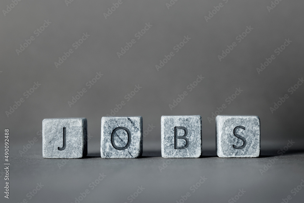 Obraz premium Word Jobs written on gray stone cube blocks. Employment, work and job concept.
